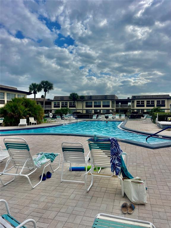 5207 Turquoise Lane, Unit 202 New Port Richey, FL 34652 - Photo 18 of 26 a roof deck with table and chairs and potted plants