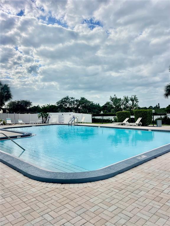 5207 Turquoise Lane, Unit 202 New Port Richey, FL 34652 - Photo 19 of 26 a view of a swimming pool with an outdoor seating and a lots of buildings
