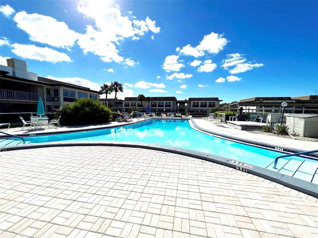 5207 Turquoise Lane, Unit 202 New Port Richey, FL 34652 - Photo 21 of 26 a view of a swimming pool and lounge chairs