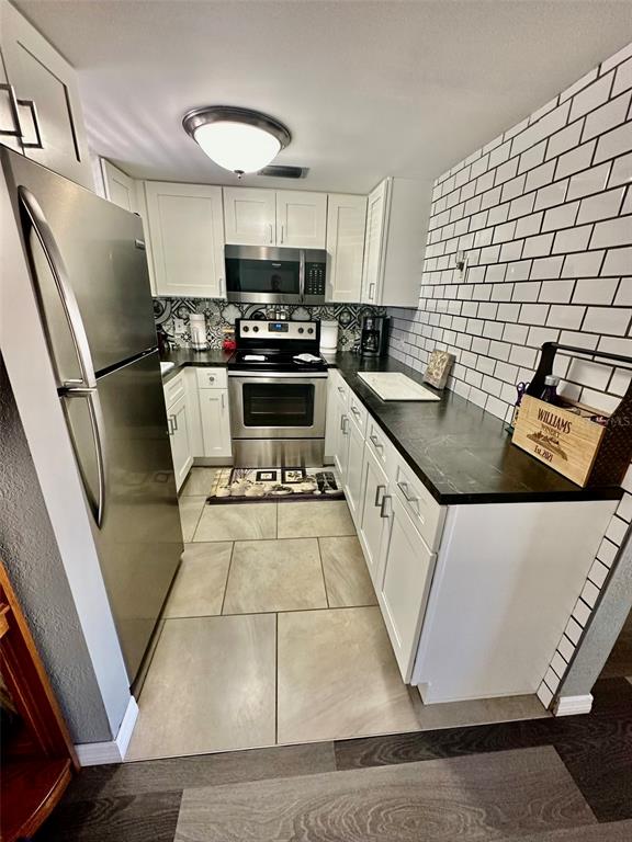 5207 Turquoise Lane, Unit 202 New Port Richey, FL 34652 - Photo 8 of 26 a kitchen with stainless steel appliances granite countertop a refrigerator a stove and a sink