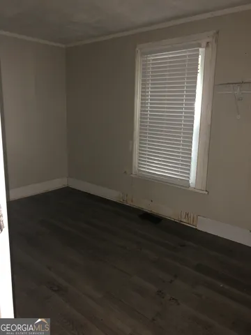 an empty room with wooden floor and a window