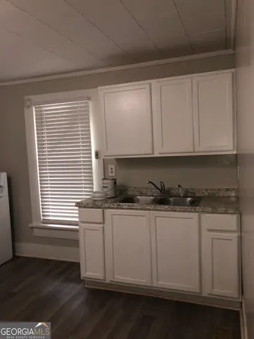 a kitchen with stainless steel appliances granite countertop a sink and cabinets with wooden floor