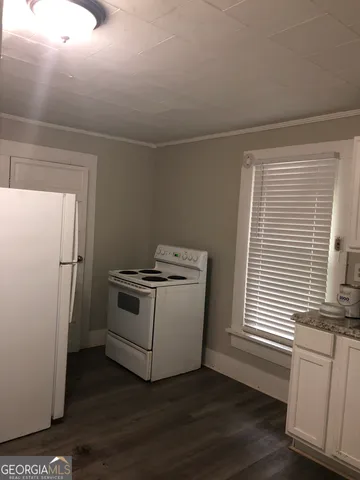 a view of a room with wooden floors and white walls