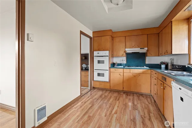 a kitchen with granite countertop white cabinets and white appliances