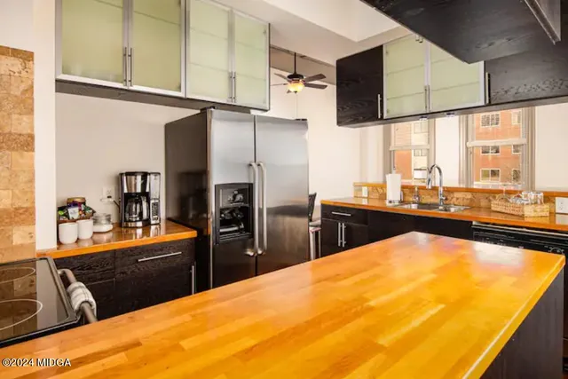 a kitchen with stainless steel appliances kitchen island granite countertop a refrigerator and a stove top oven