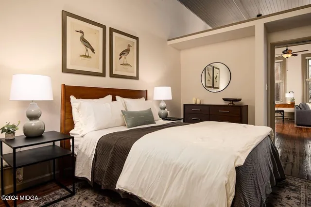 a bedroom with bed and painting on the wall