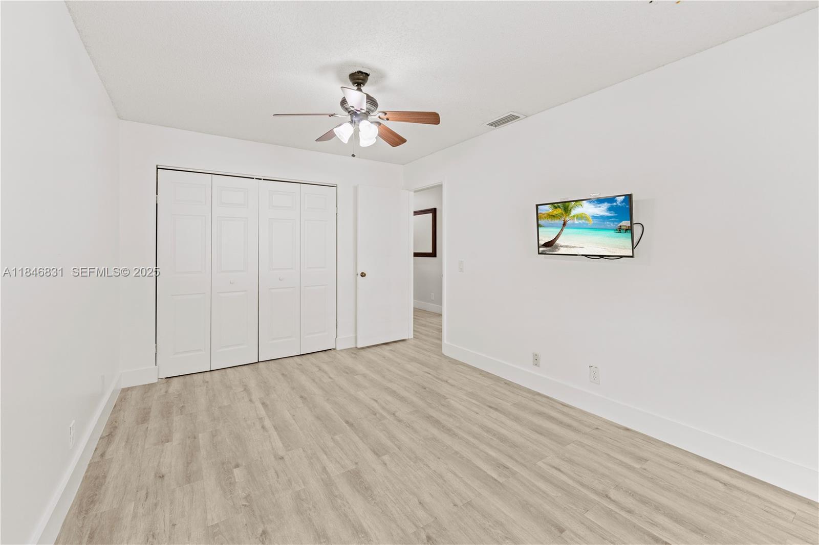 6603 Via Regina, Unit 50 Boca Raton, FL 33433 - Photo 31 of 48 a view of empty room with wooden floor and fan