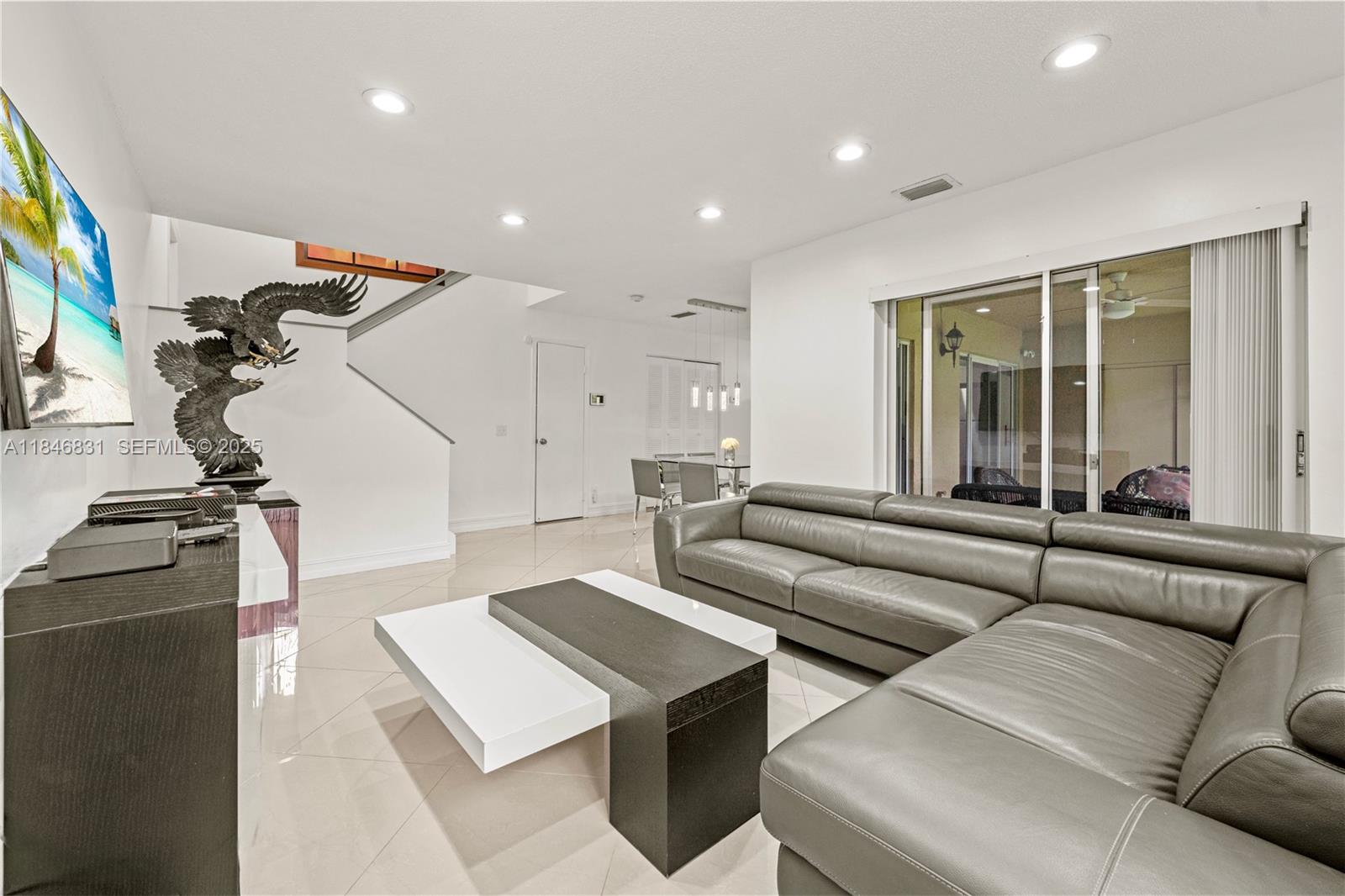 6603 Via Regina, Unit 50 Boca Raton, FL 33433 - Photo 9 of 48 a living room with couches and a flat screen tv