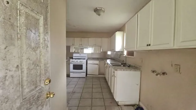 a kitchen with a refrigerator sink and cabinets