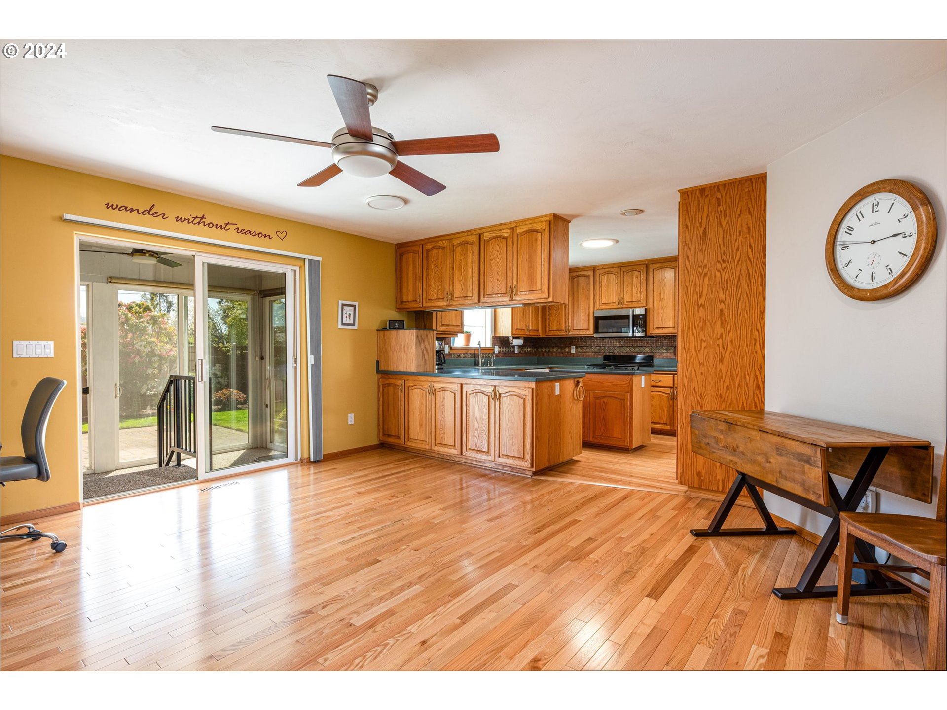 1769 Carriage Place Springfield, OR 97477 - Photo 15 of 23 a kitchen with stainless steel appliances granite countertop a refrigerator a stove a sink a dining table and chairs with wooden floor