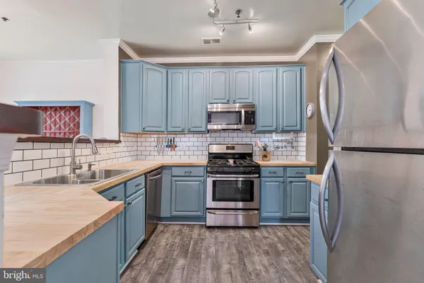 a kitchen with stainless steel appliances granite countertop a refrigerator stove and sink