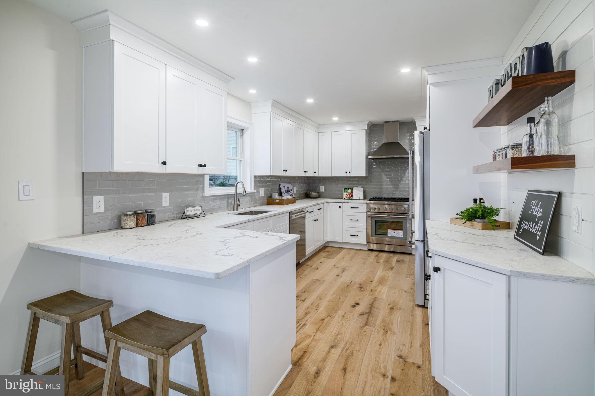745 Cedar Avenue Haddonfield, NJ 08033 - Photo 21 of 55 a kitchen with a sink a stove a refrigerator and white cabinets with wooden floor
