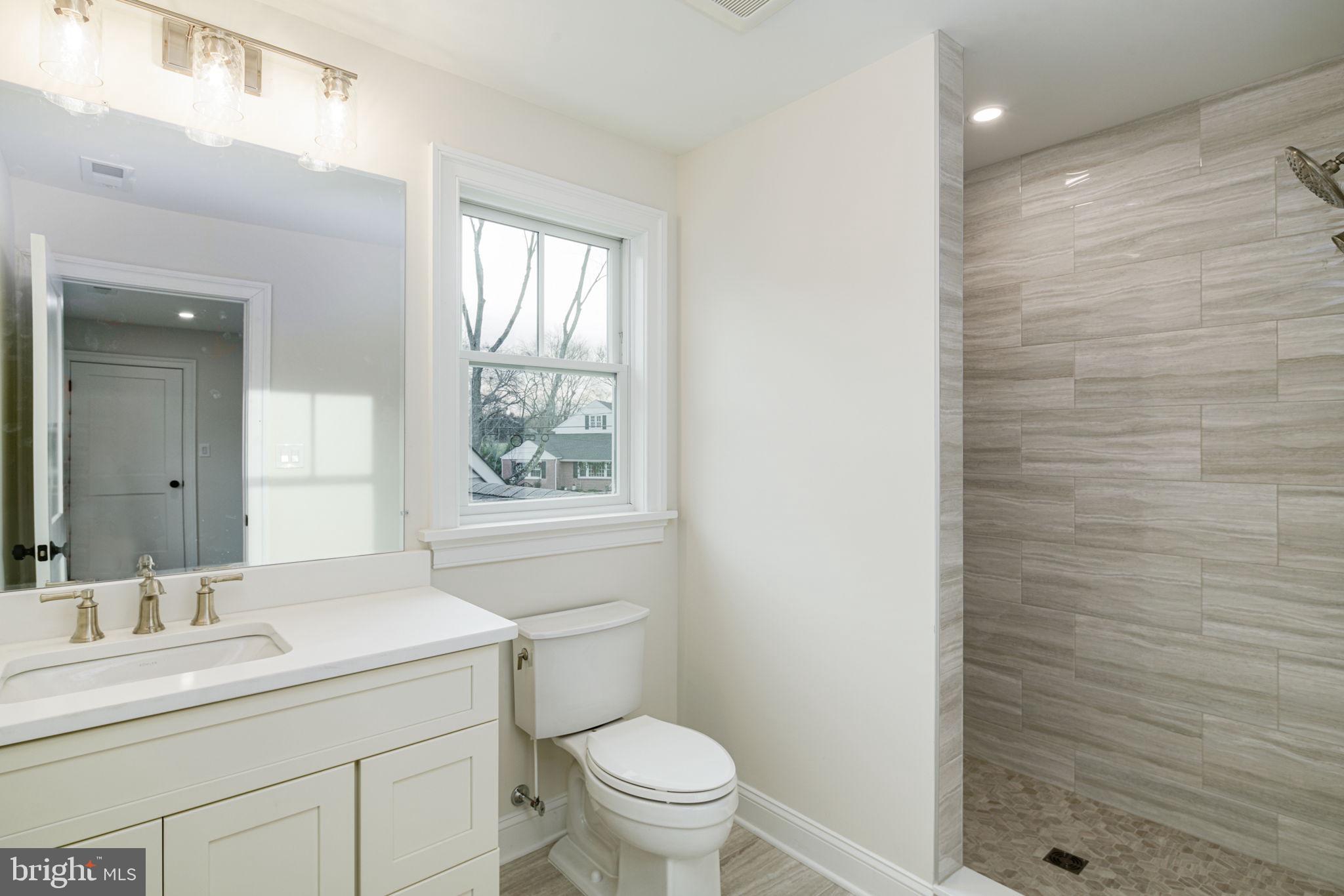 745 Cedar Avenue Haddonfield, NJ 08033 - Photo 39 of 55 a bathroom with a granite countertop sink toilet a large mirror and a window