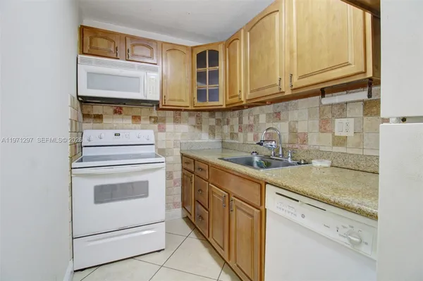a kitchen with granite countertop cabinets stainless steel appliances and a sink