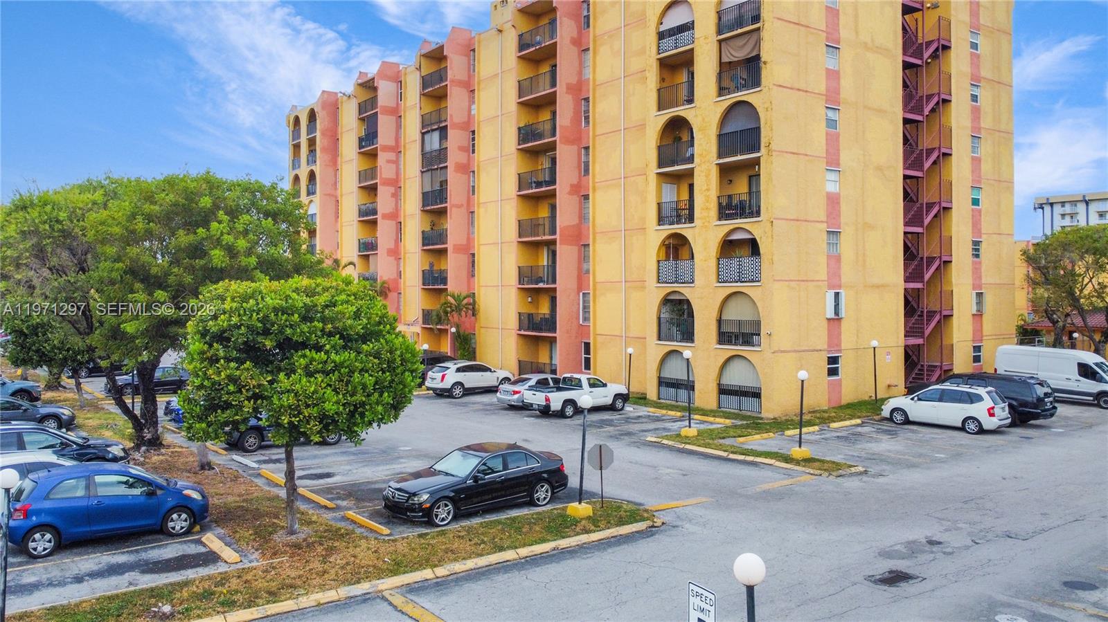 4717 Northwest 7th Street, Unit 60410 Miami, FL 33126 - Photo 19 of 19 a car parked beside a road next to tall buildings