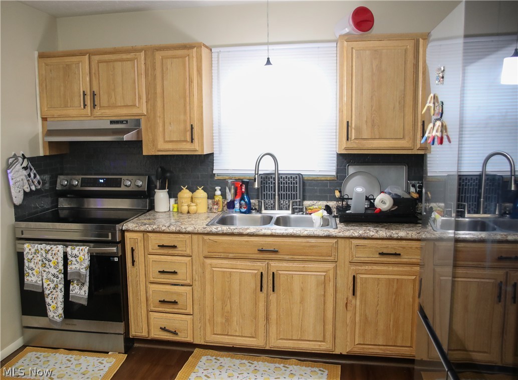 1258 Vane Avenue Akron, OH 44310 - Photo 4 of 12 Kitchen featuring wood-finish cabinetry, stainless steel appliances, dark tile backsplash, a double basin sink, and laminate countertops