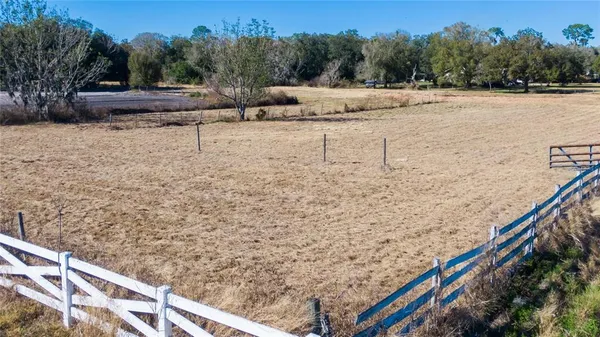 an aerial view of a house with a yard and lake view