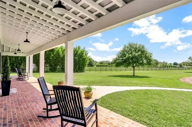 a view of a swimming pool and deck with a big yard