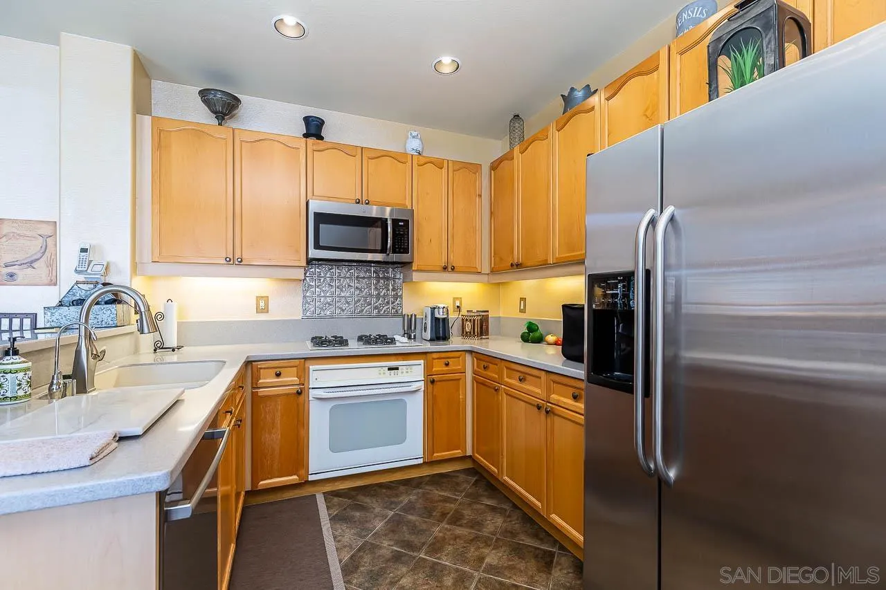 2477 Fallbrook Place Escondido, CA 92027 - Photo 10 of 28 a kitchen with stainless steel appliances granite countertop a sink stove and refrigerator
