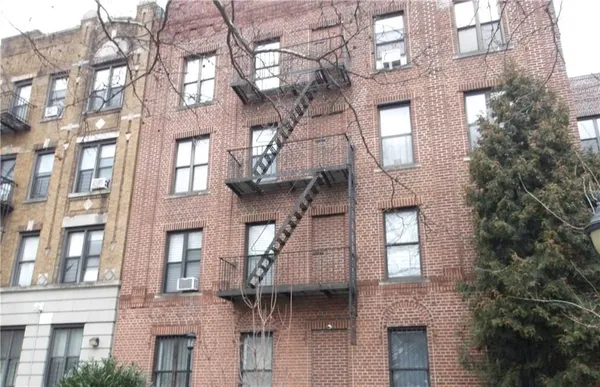 a front view of a building with a tree