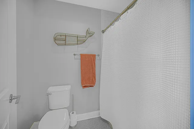 a white toilet sitting next to a white wall