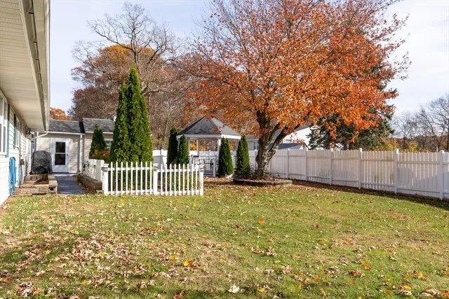 a view of a house with a small yard and wooden fence