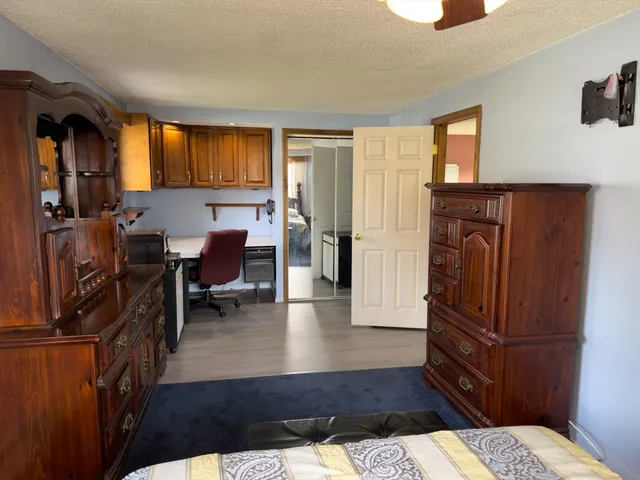 a bedroom with a bed dresser and a flat tv screen