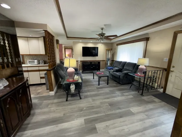 a view of a dining room with furniture a chandelier and wooden floor
