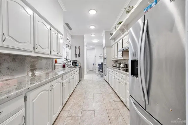 a large kitchen with stainless steel appliances granite countertop lots of counter top space and cabinets