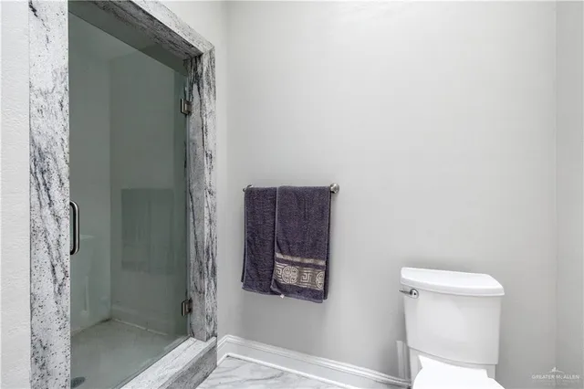 a bathroom with a toilet and a shower