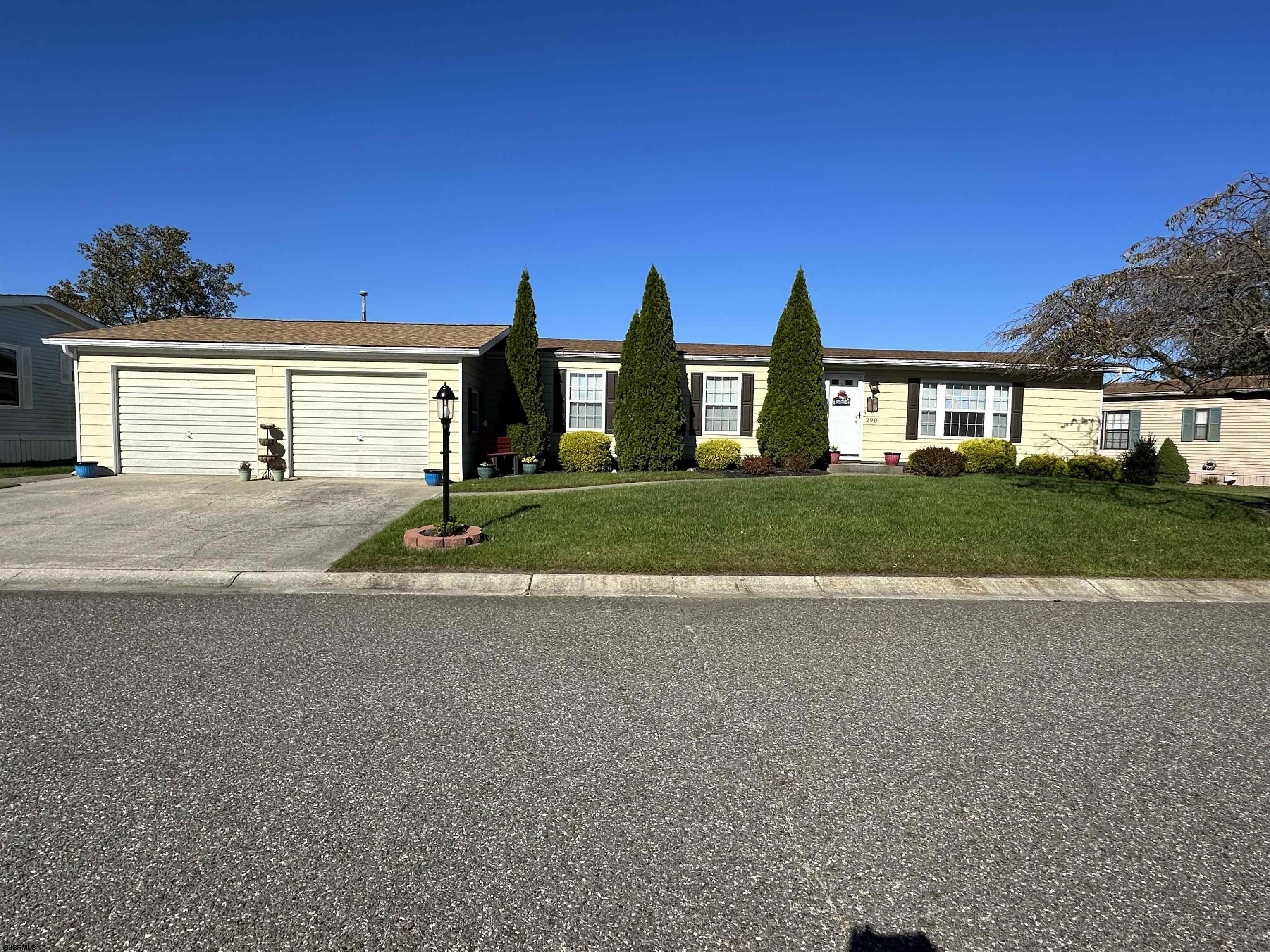 a view of road and red trees in front of house