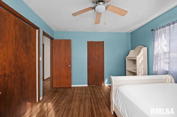 a bedroom with a bed and a large mirror