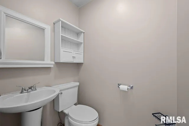 a bathroom with a sink a toilet and mirror