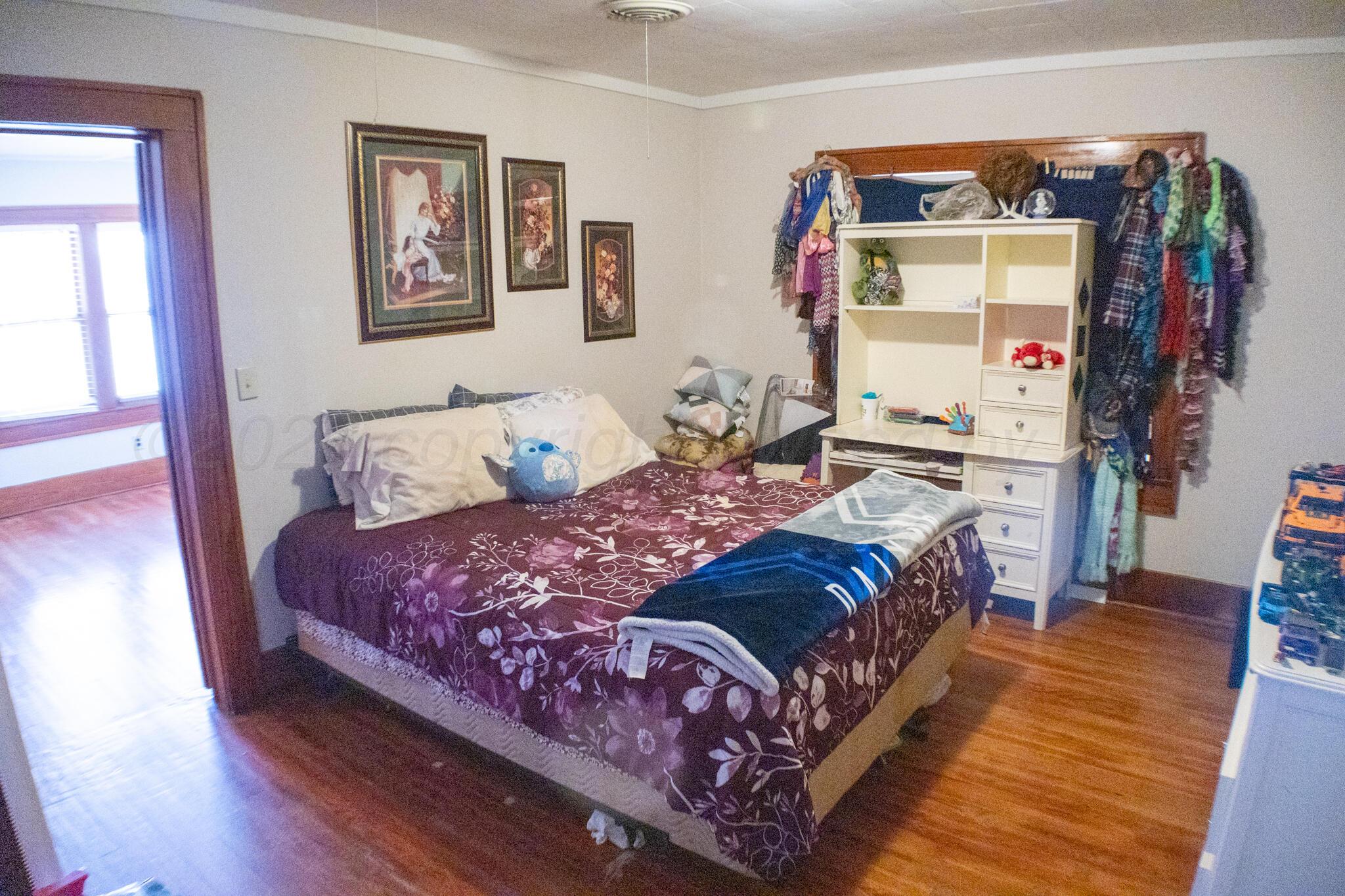 801 North Main Street McLean, TX 79057 - Photo 20 of 24 a bedroom with a bed and wooden floor