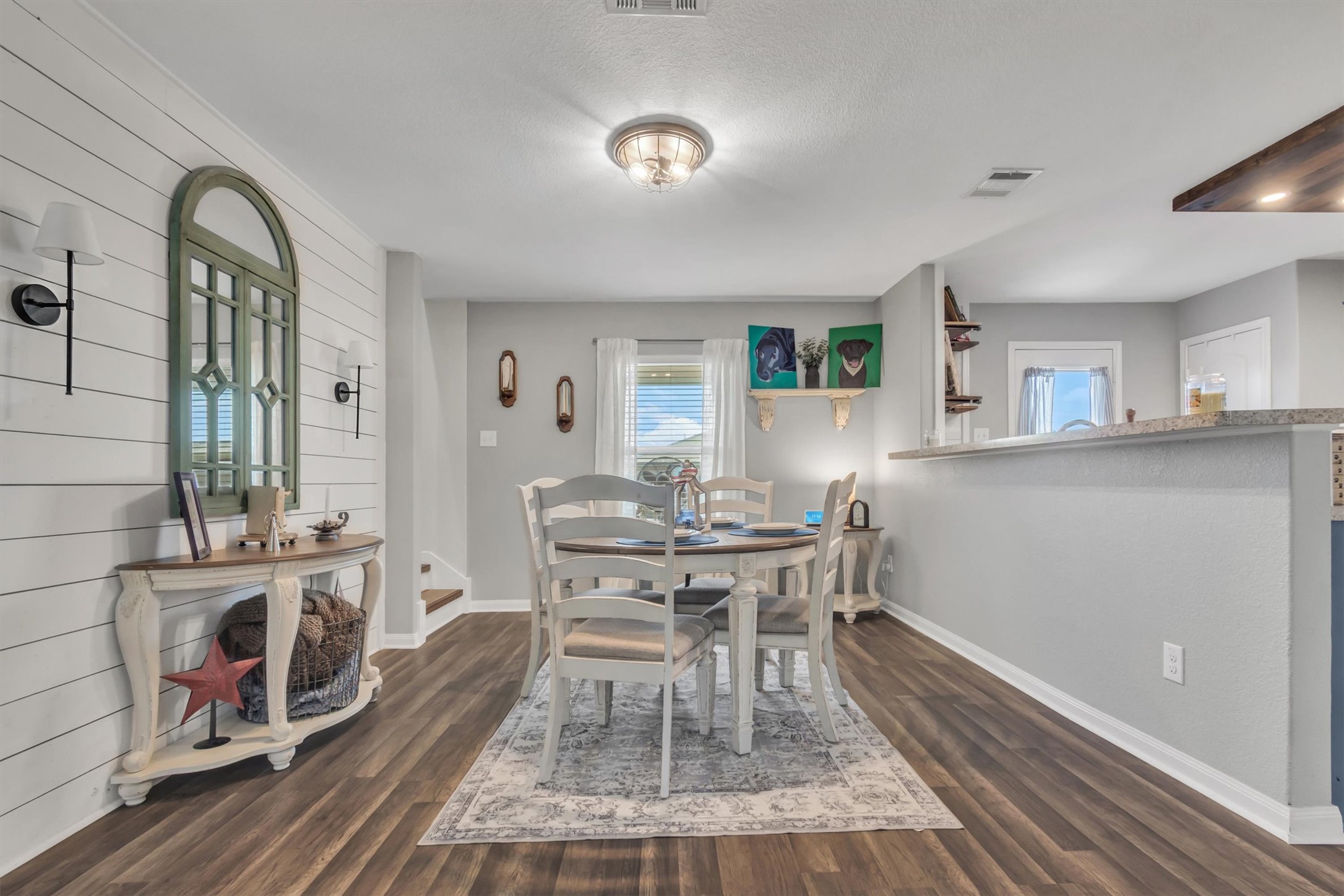 100 Wincliff Cove, Unit 13D Jarrell, TX 76537 - Photo 3 of 21 Hardwood-style flooring extends through this welcoming dining area, accented by a decorative shiplap wall.