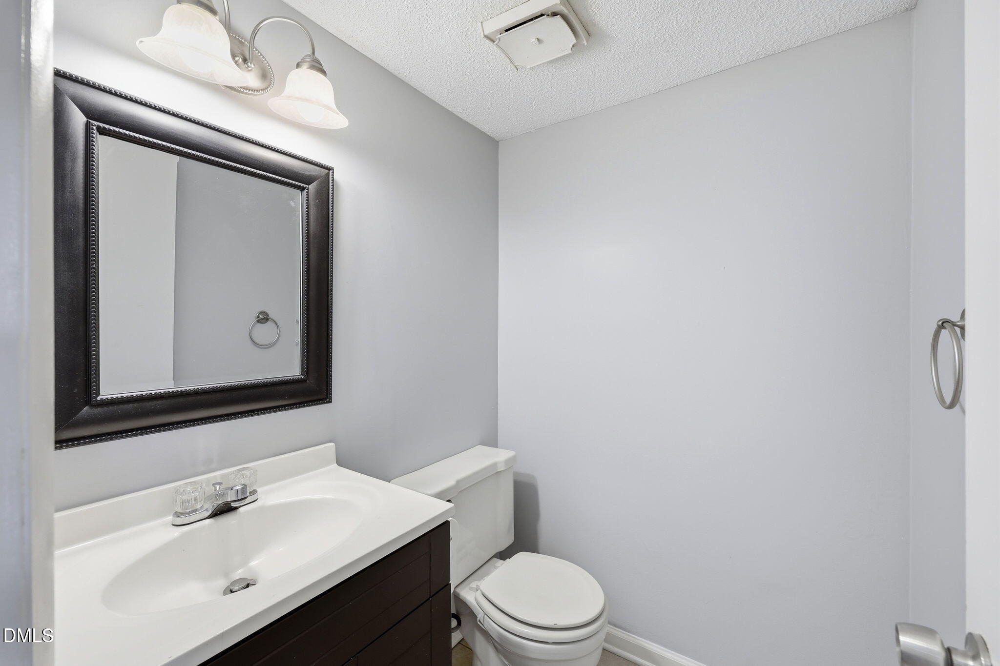5043 Tall Pines Court Raleigh, NC 27609 - Photo 12 of 37 a bathroom with a toilet sink vanity and mirror