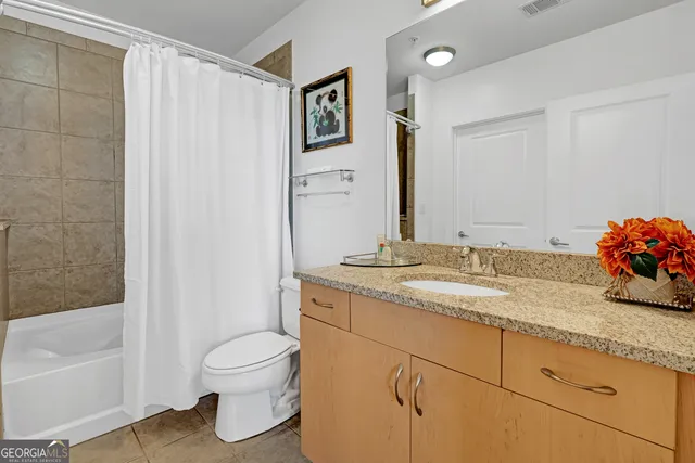 a bathroom with a granite countertop sink toilet and shower