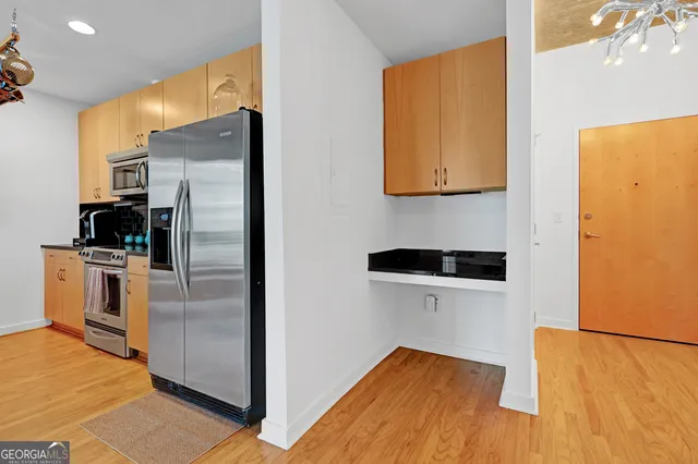 a view of a refrigerator in kitchen and a sink