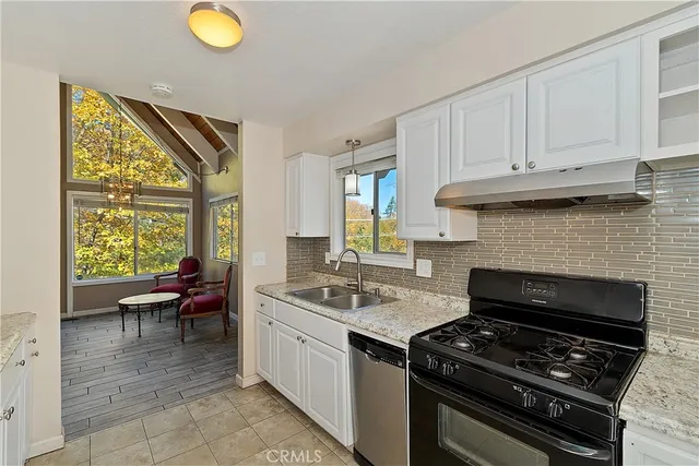 a kitchen with a stove a sink and wooden cabinets