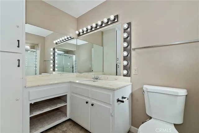 a bathroom with a granite countertop sink toilet and shower