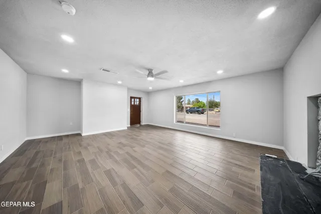 an empty room with wooden floor and window