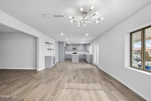 a view of a kitchen with kitchen island a sink wooden floor and a window