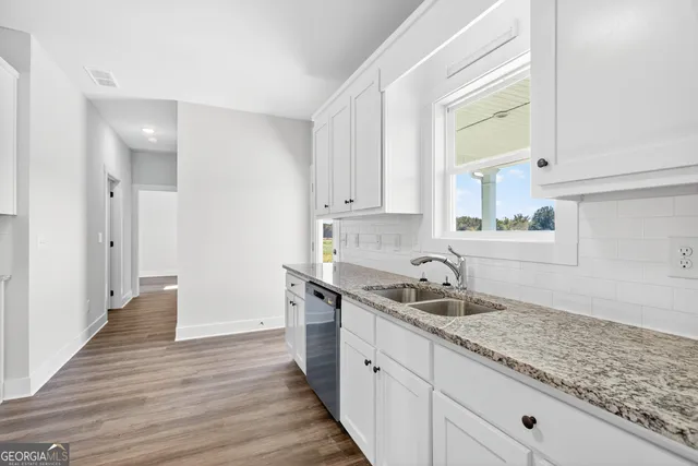 a kitchen with granite countertop a sink and cabinets