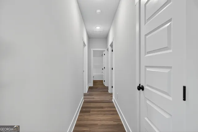 a view of a hallway with wooden floor and staircase