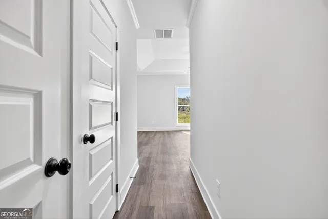 a view of a hallway with wooden floor and staircase