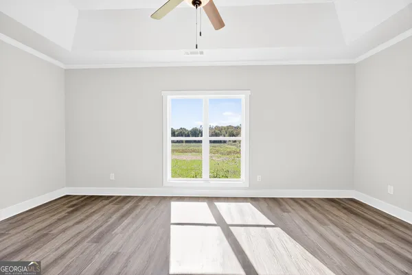 an empty room with wooden floor and windows