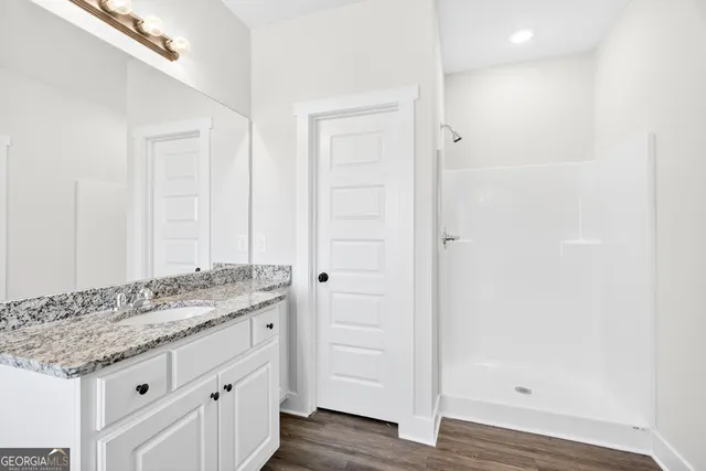 a bathroom with a granite countertop sink and a mirror