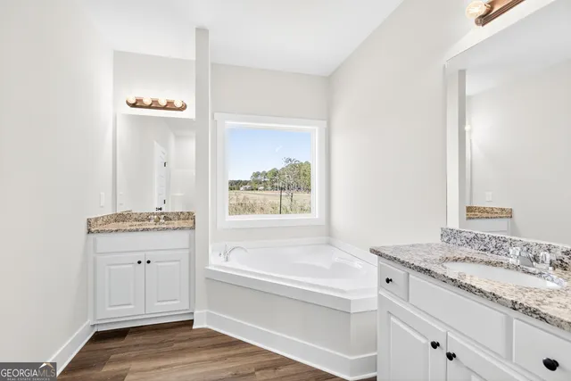 a bathroom with a granite countertop bathtub a sink and a mirror