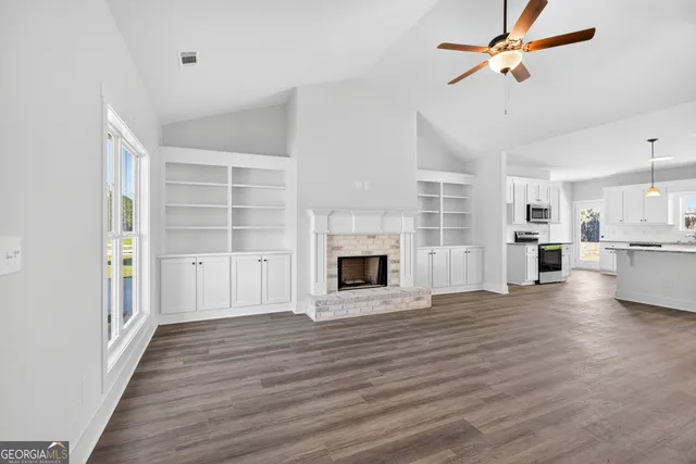 a view of a room with wooden floor and a fireplace