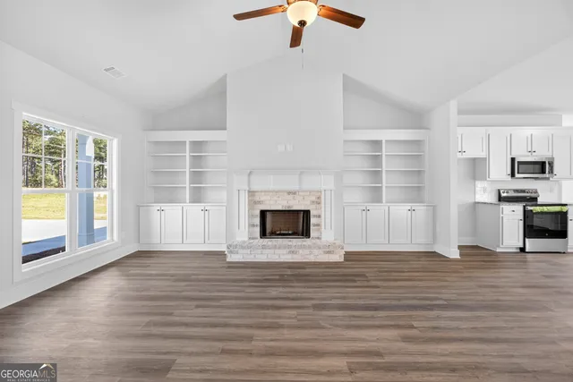 a view of a livingroom with a fireplace wooden floor and window